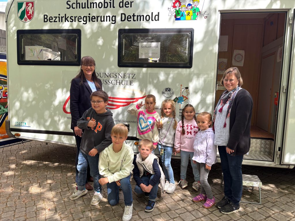 Schulkinder posieren vor dem Schulmobil der Bezirksregierung Detmold